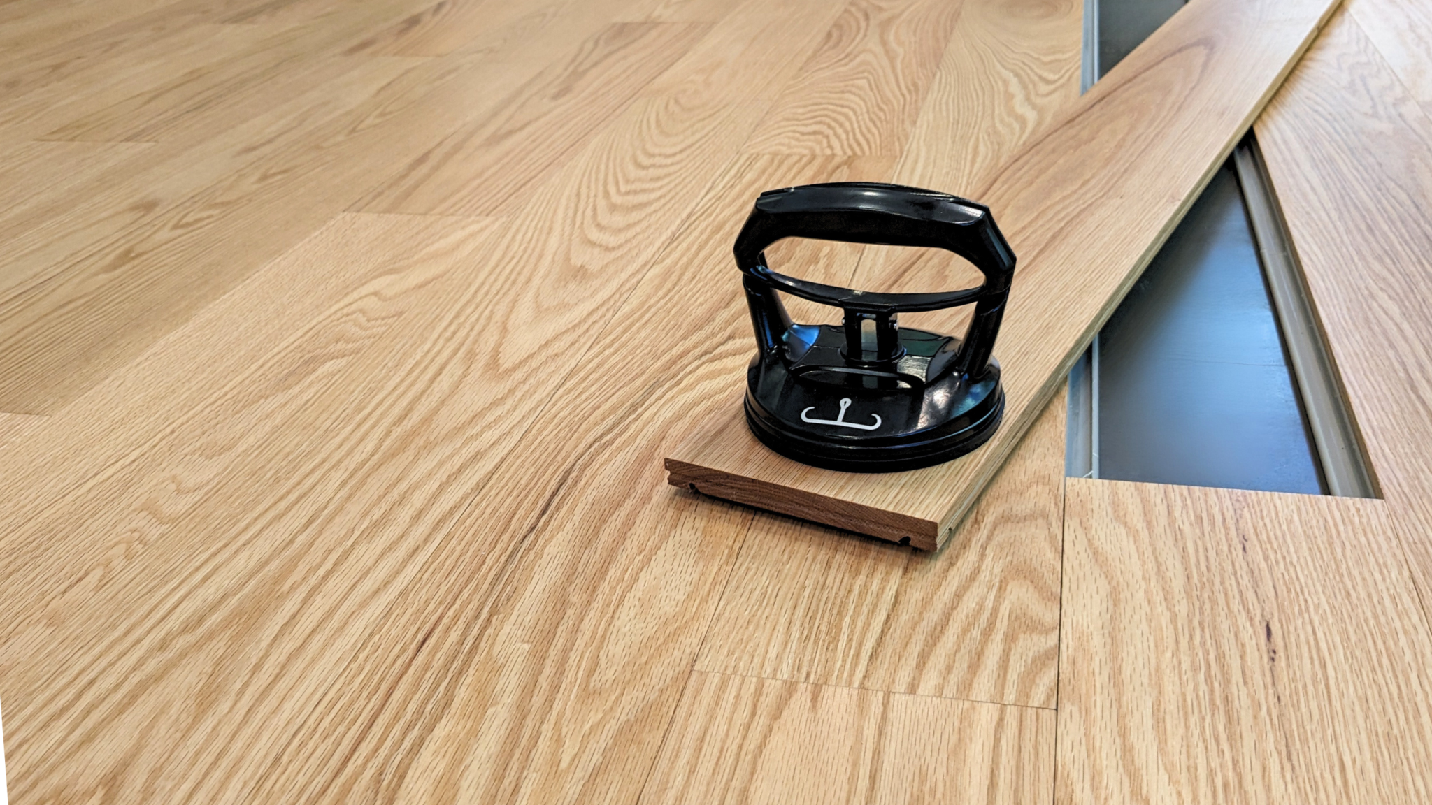 Full Assembly Tool Kit with suction cup and PVC shears on wooden floor.