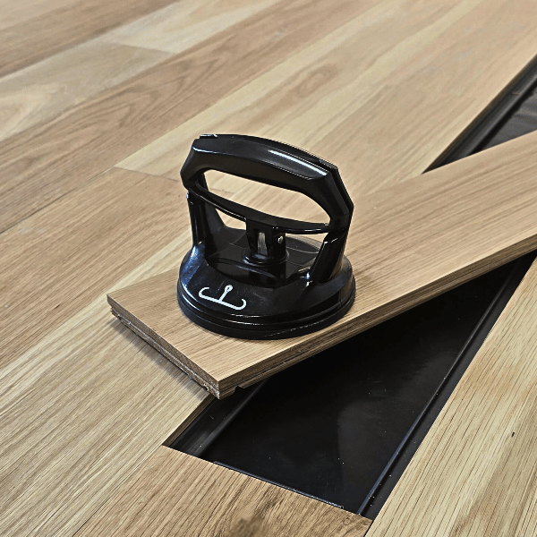 Black flooring tool on a wooden floor